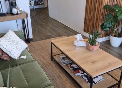 Revel Studio's inviting lounge area in London, Ontario, CA, with a green sofa and wooden coffee table.