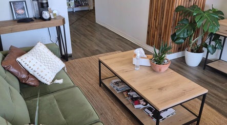 Revel Studio's inviting lounge area in London, Ontario, CA, with a green sofa and wooden coffee table.