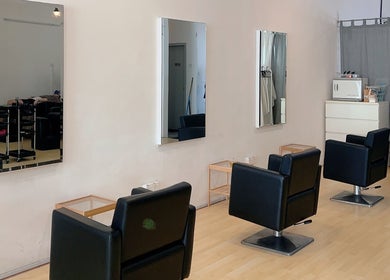 Modern salon interior at Hair Detail Studio in Balakong, Selangor, MY, featuring stylish black chairs and mirrors.