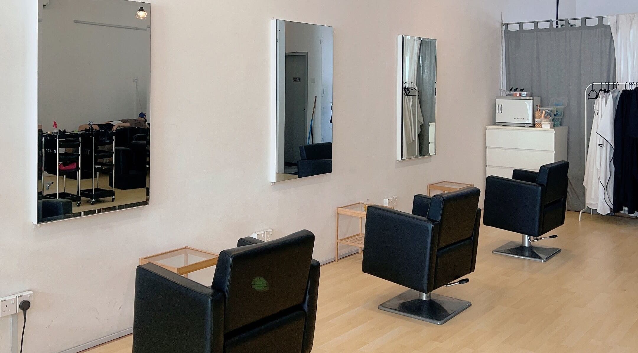 Modern salon interior at Hair Detail Studio in Balakong, Selangor, MY, featuring stylish black chairs and mirrors.