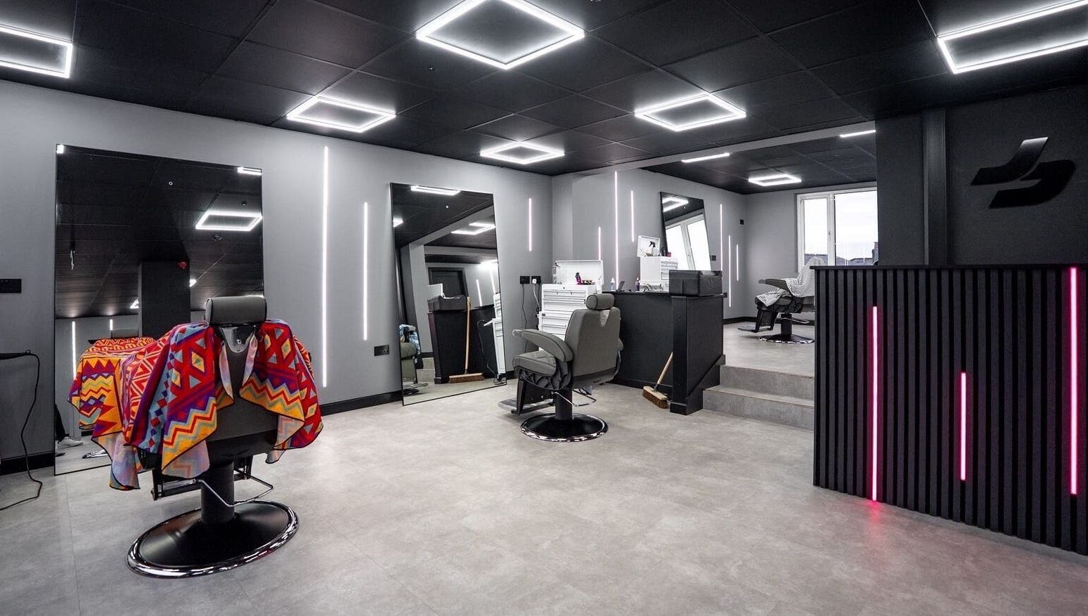 Modern interior of Just Barbering, Isle Of Man, Onchan, showcasing stylish barber chairs and contemporary lighting.