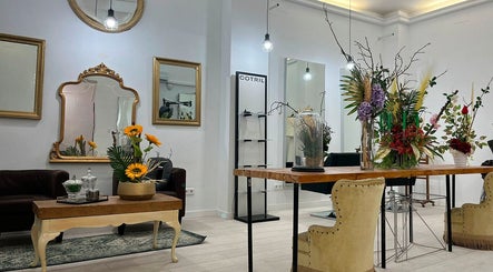 Interior elegante de Aude Perruqueria en Barcelona, Catalunya, ES, con mesas de madera y espejos antiguos.