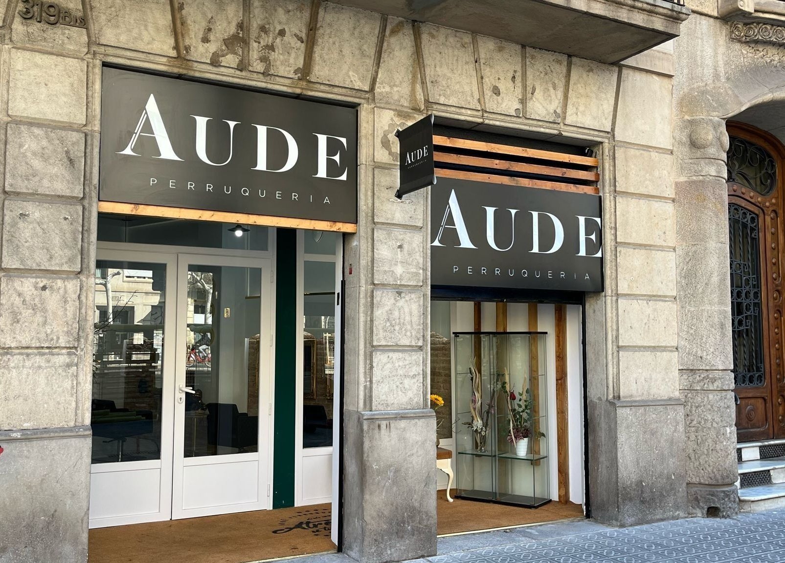 Fachada de Aude Perruqueria en Barcelona, Catalunya, ES, mostrando su entrada elegante y moderna.