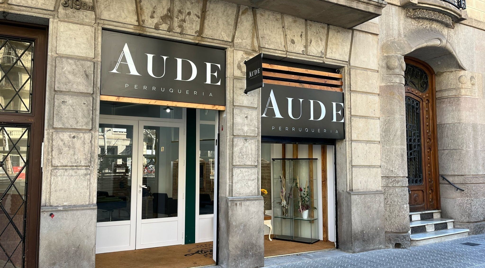 Fachada de Aude Perruqueria en Barcelona, Catalunya, ES, mostrando su entrada elegante y moderna.