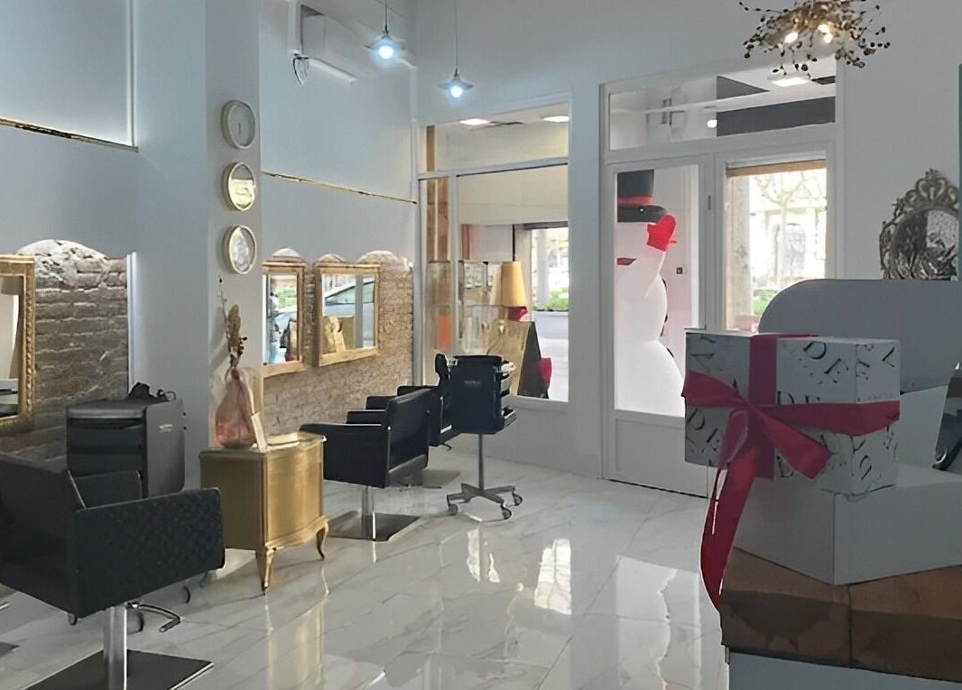 Interior elegante de Aude Perruqueria en Barcelona, Catalunya, ES, con espejos dorados y sillas modernas.