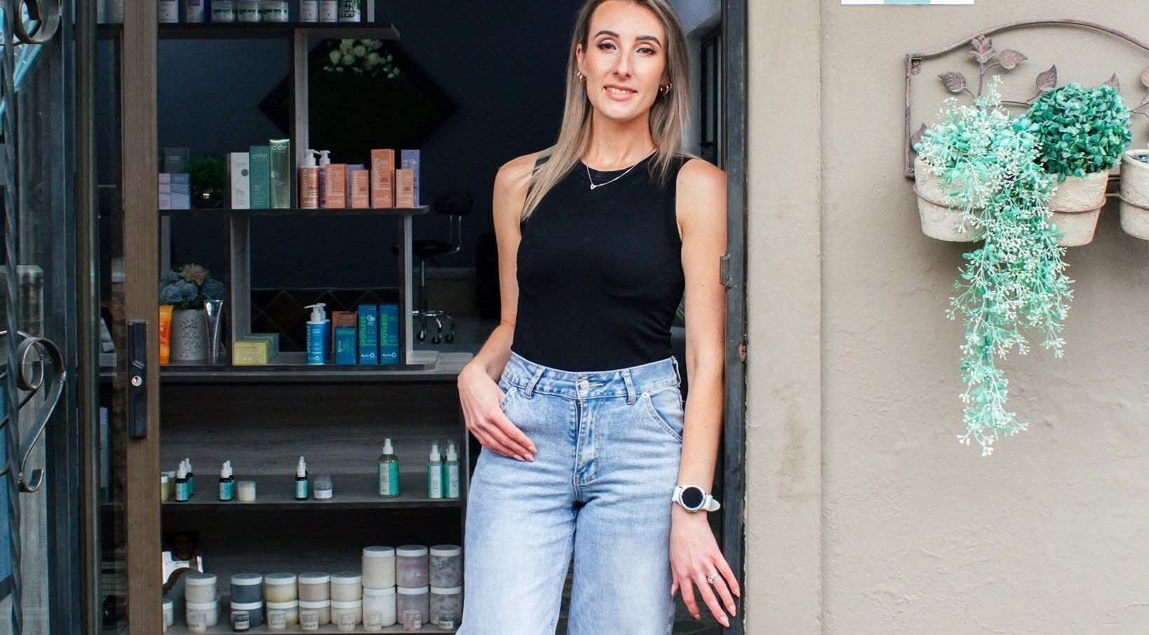 Welcome to Am Beautify in Benoni, Gauteng, ZA. Woman in black top and denim jeans stands at the entrance.