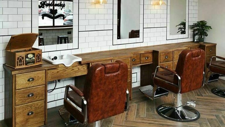 Chic barber setup at Asylum287 in Barrow-in-Furness, England, GB with classic leather chairs and wood decor.