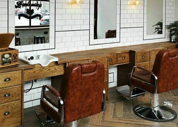 Chic barber setup at Asylum287 in Barrow-in-Furness, England, GB with classic leather chairs and wood decor.