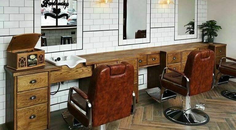 Chic barber setup at Asylum287 in Barrow-in-Furness, England, GB with classic leather chairs and wood decor.