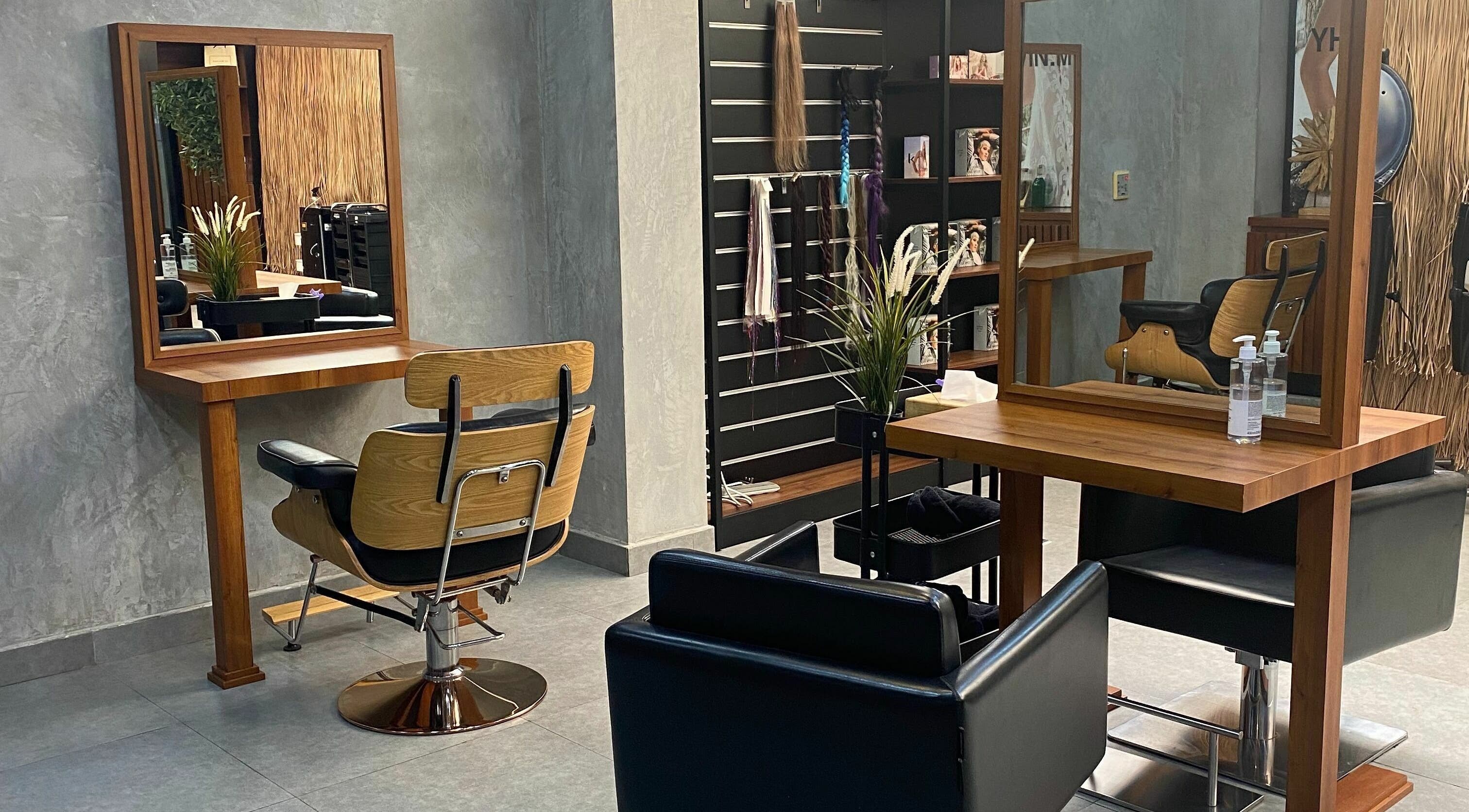 Elegantly designed interior of Brush Salon in Dubai, AE, featuring wooden styling stations and modern chairs.