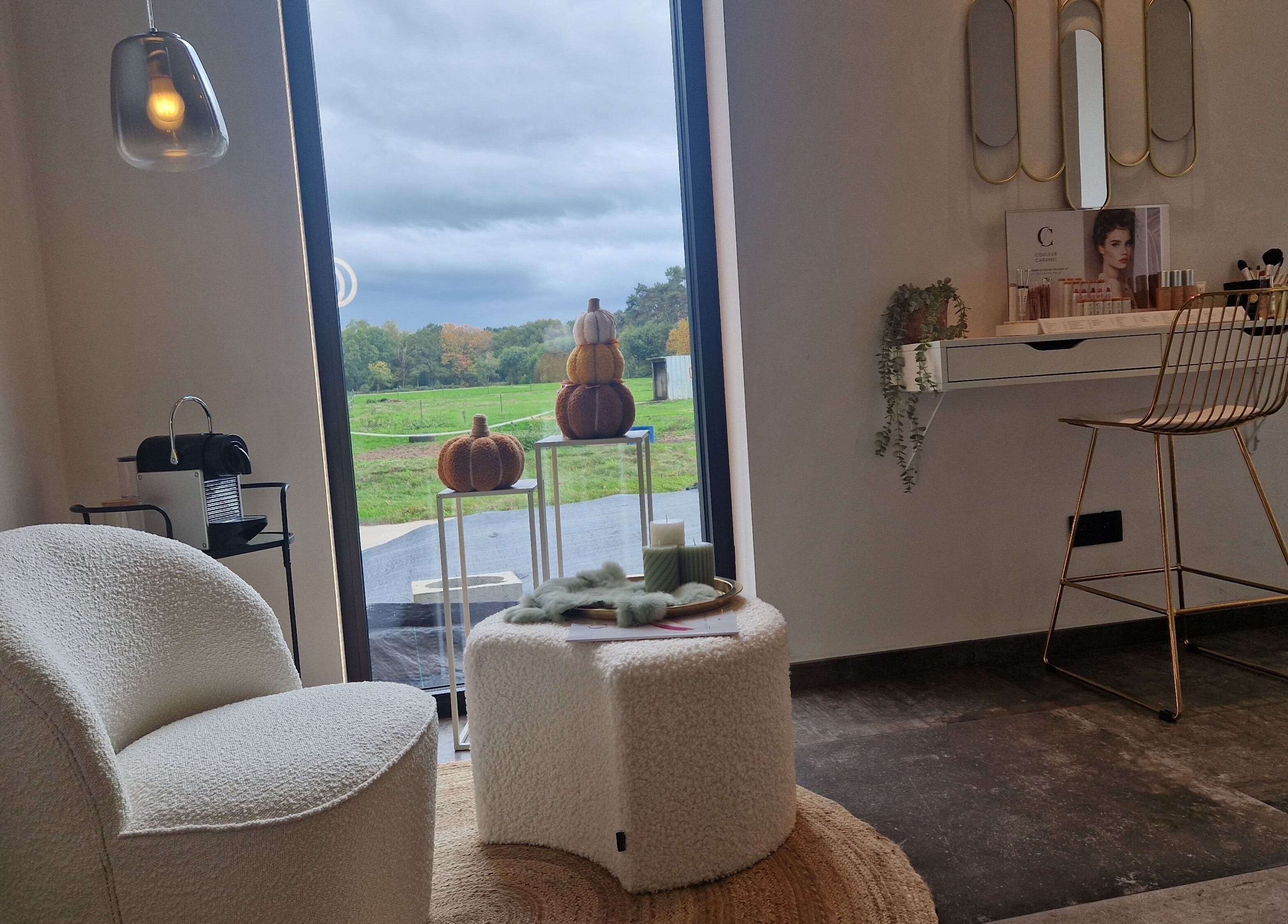 Gezellige hoek bij JOY in Meerhout, Vlaanderen, BE met stoel en make-up tafel bij raam met uitzicht.