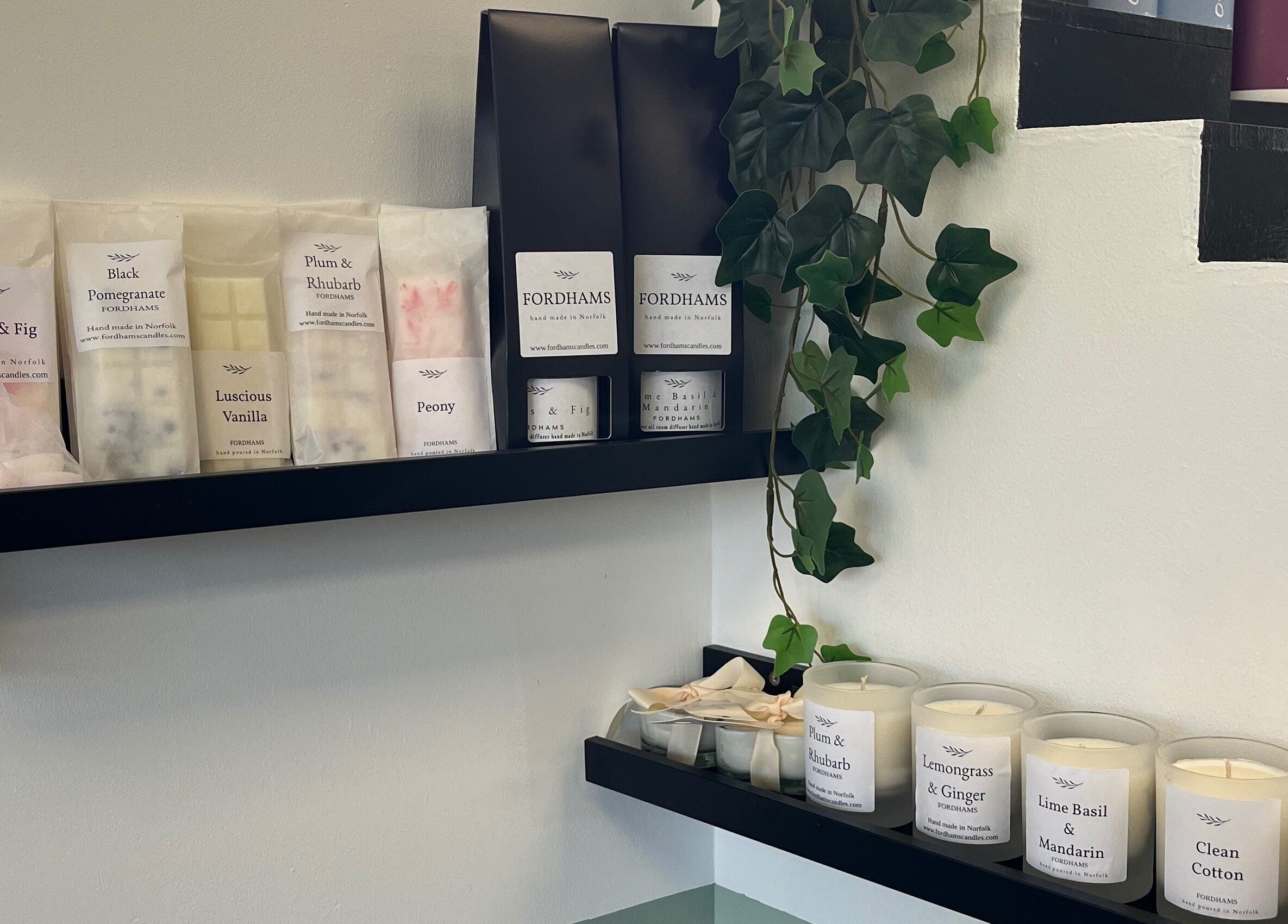 Charli's Hair Studio in Beccles, England displays luxury scented candles on sleek black shelves.