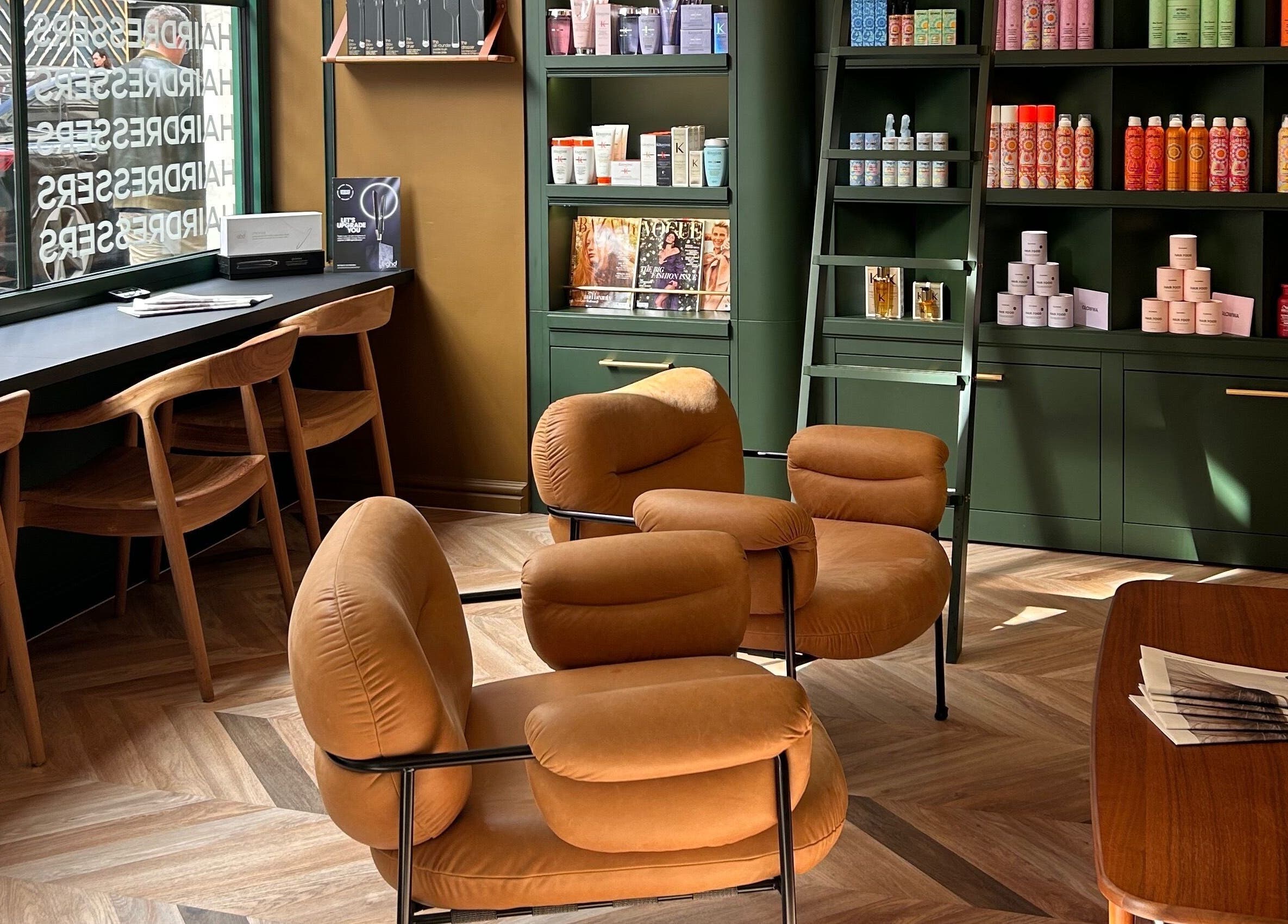Relaxing seating area at Hollie Rose Clarke, London, England, GB, featuring chic chairs and modern shelving.