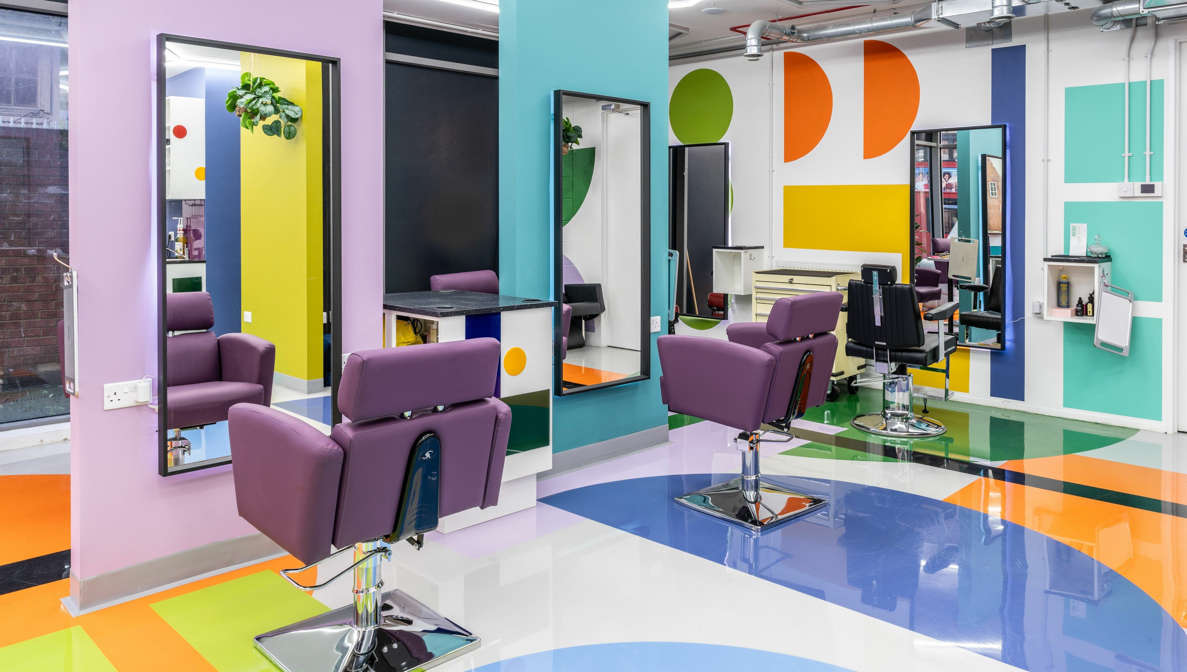 Colorful salon interior at Fruittii London, located in London, England, GB, features modern chairs and mirrors.