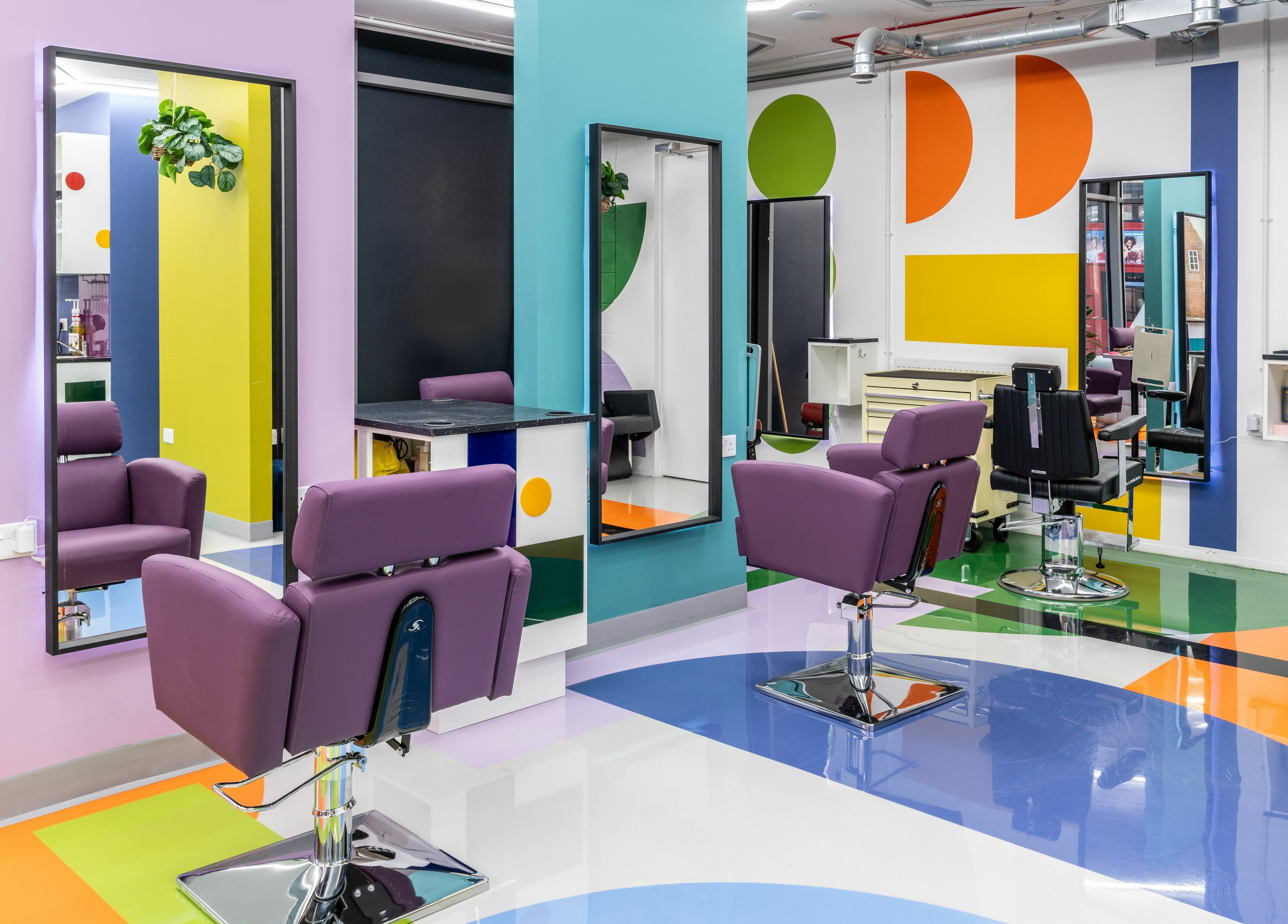 Colorful salon interior at Fruittii London, located in London, England, GB, features modern chairs and mirrors.