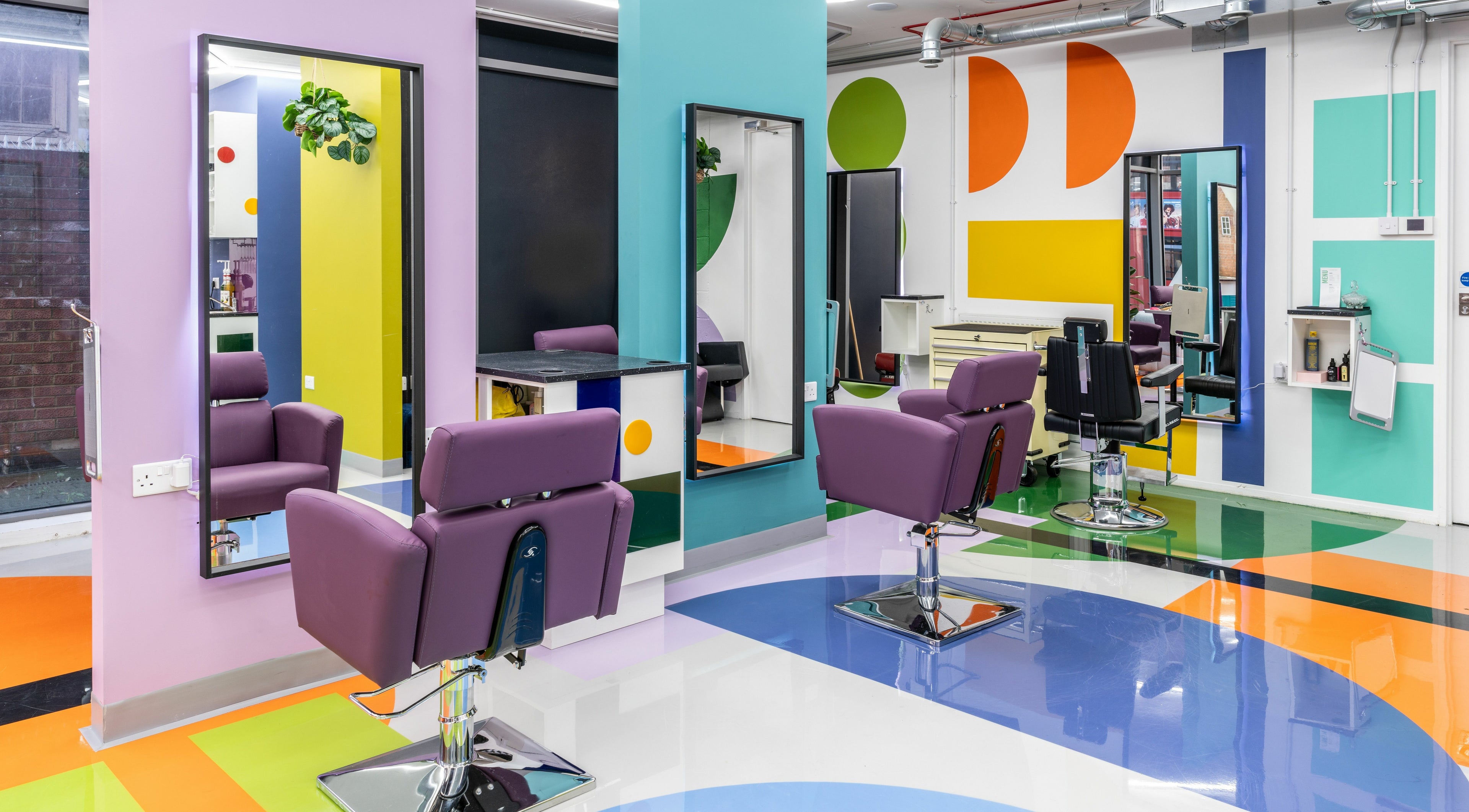 Colorful salon interior at Fruittii London, located in London, England, GB, features modern chairs and mirrors.