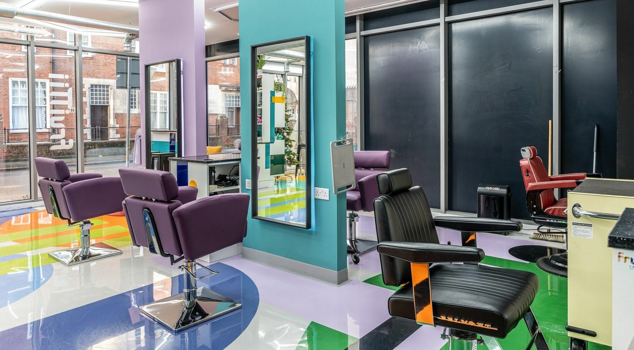 Inside Fruittii London, England, GB: colorful styling chairs and modern decor in a chic beauty salon.