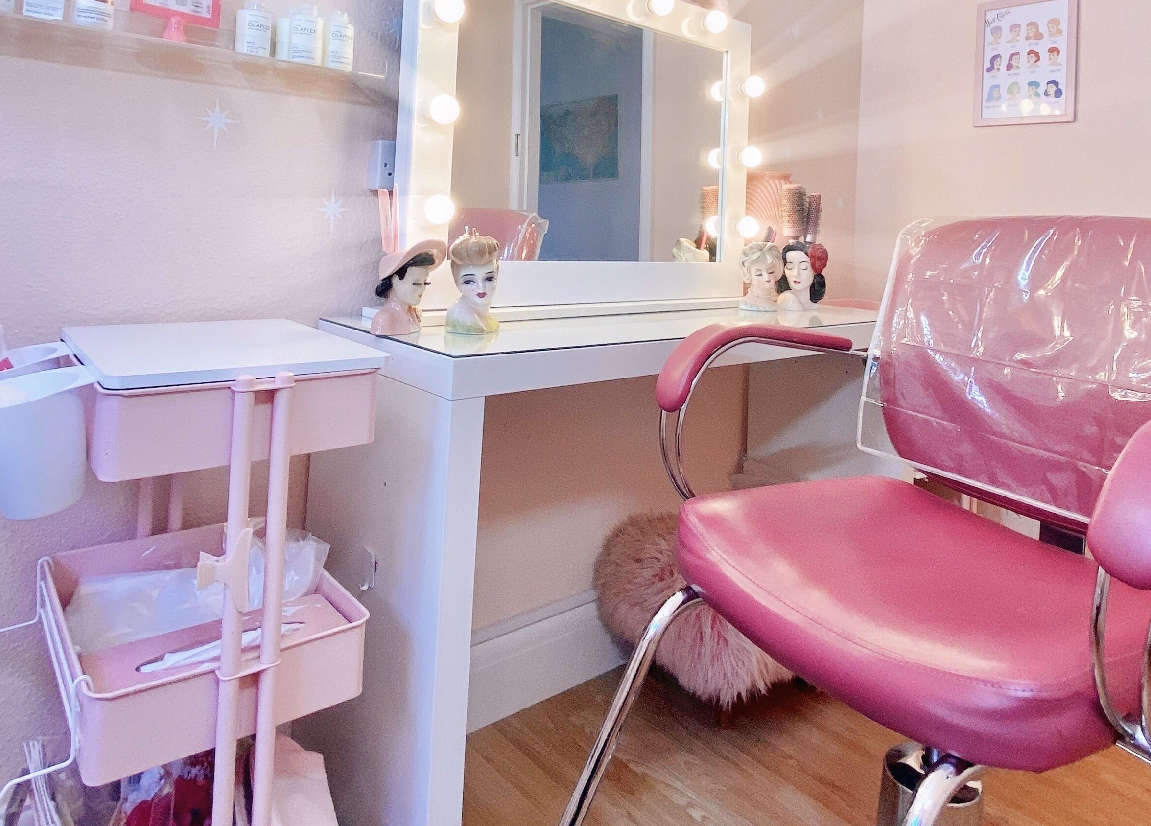 Chic salon station at Lucilles Locks, Long Eaton, England, GB, featuring a pink chair and vanity mirrors.