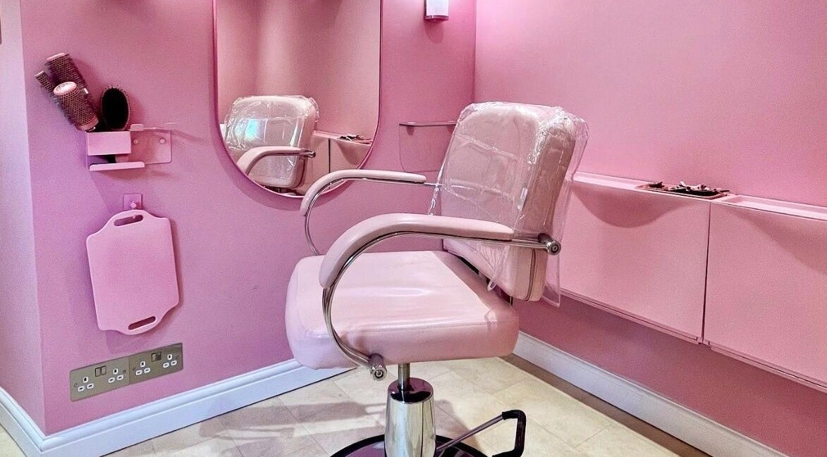 Chic pink salon chair and mirror at Lucilles Locks, Long Eaton, England, GB offering a modern beauty experience.