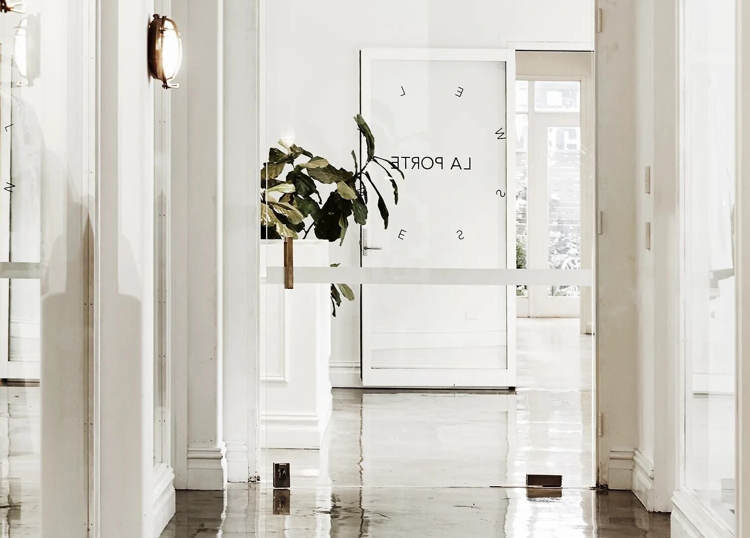 Bright and sleek hallway in La Porte Wellness, Rosebery, New South Wales, AU showcasing minimalist design and greenery.