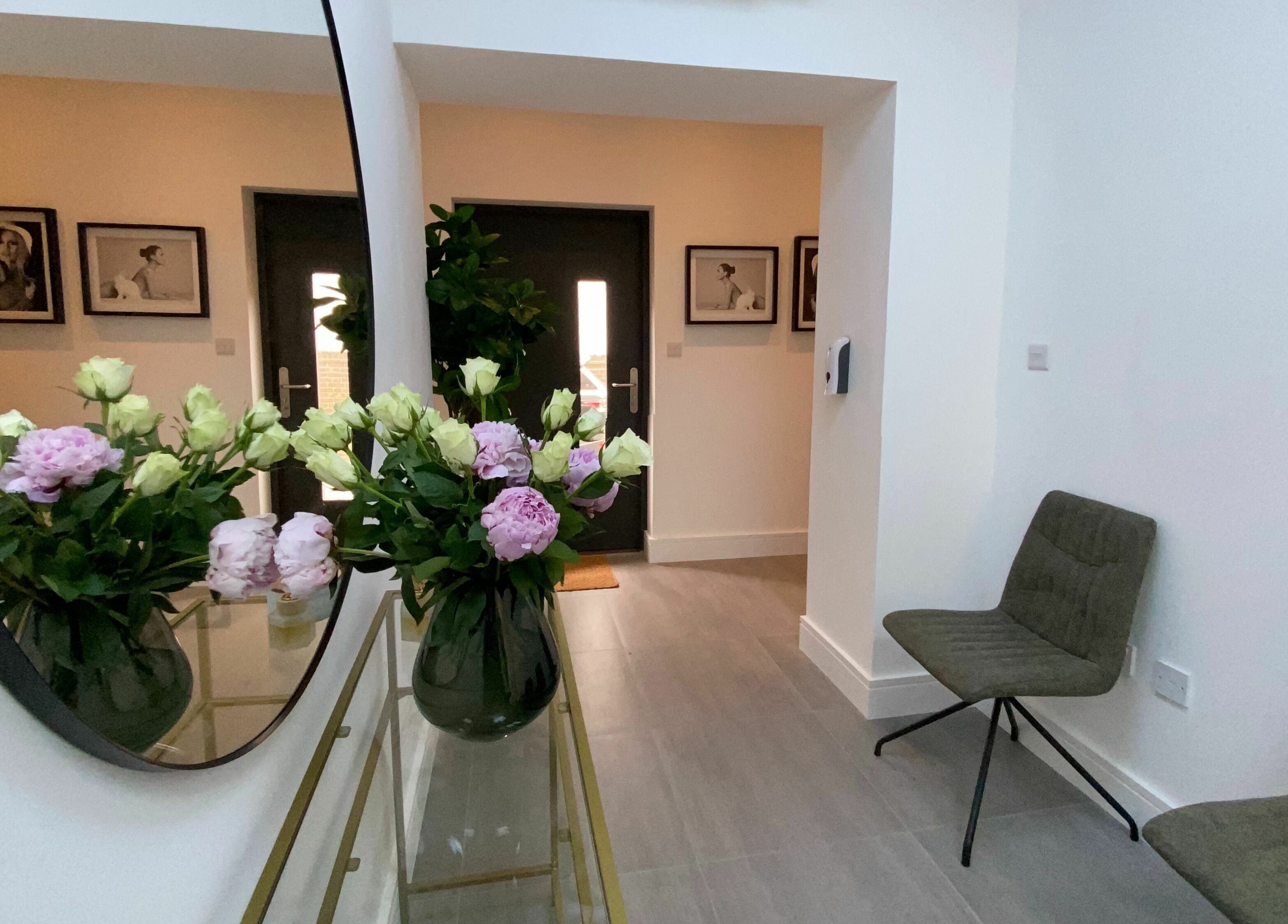 Elegant entrance of Beautybar Aesthetics in London, England, GB with floral decor and chic seating.