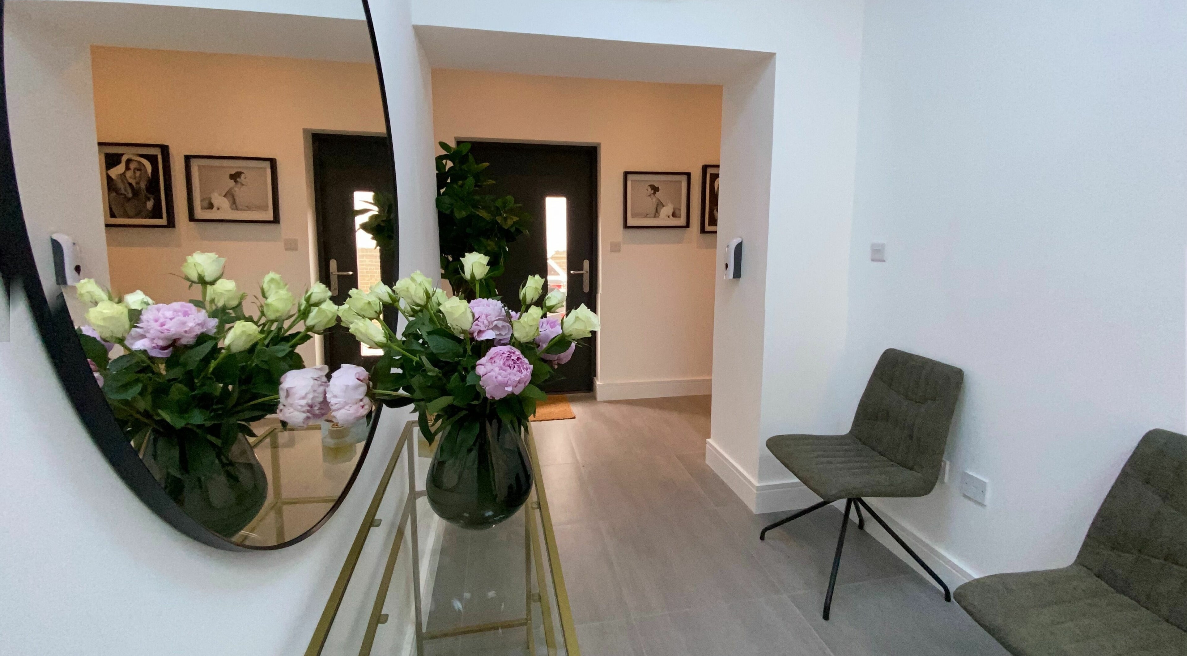 Elegant entrance of Beautybar Aesthetics in London, England, GB with floral decor and chic seating.