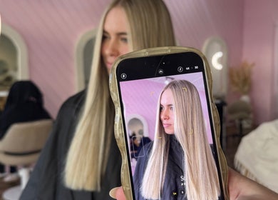 Professional hairstyle at La Lars Hair, Maryborough, Queensland showcased through a phone camera in a salon ambiance.