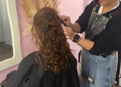Stylist crafting a curly updo at La Lars Hair, Maryborough, Queensland, AU.