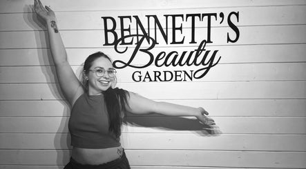 Woman smiling at Bennett’s Beauty Garden sign in Warrington, England, GB.