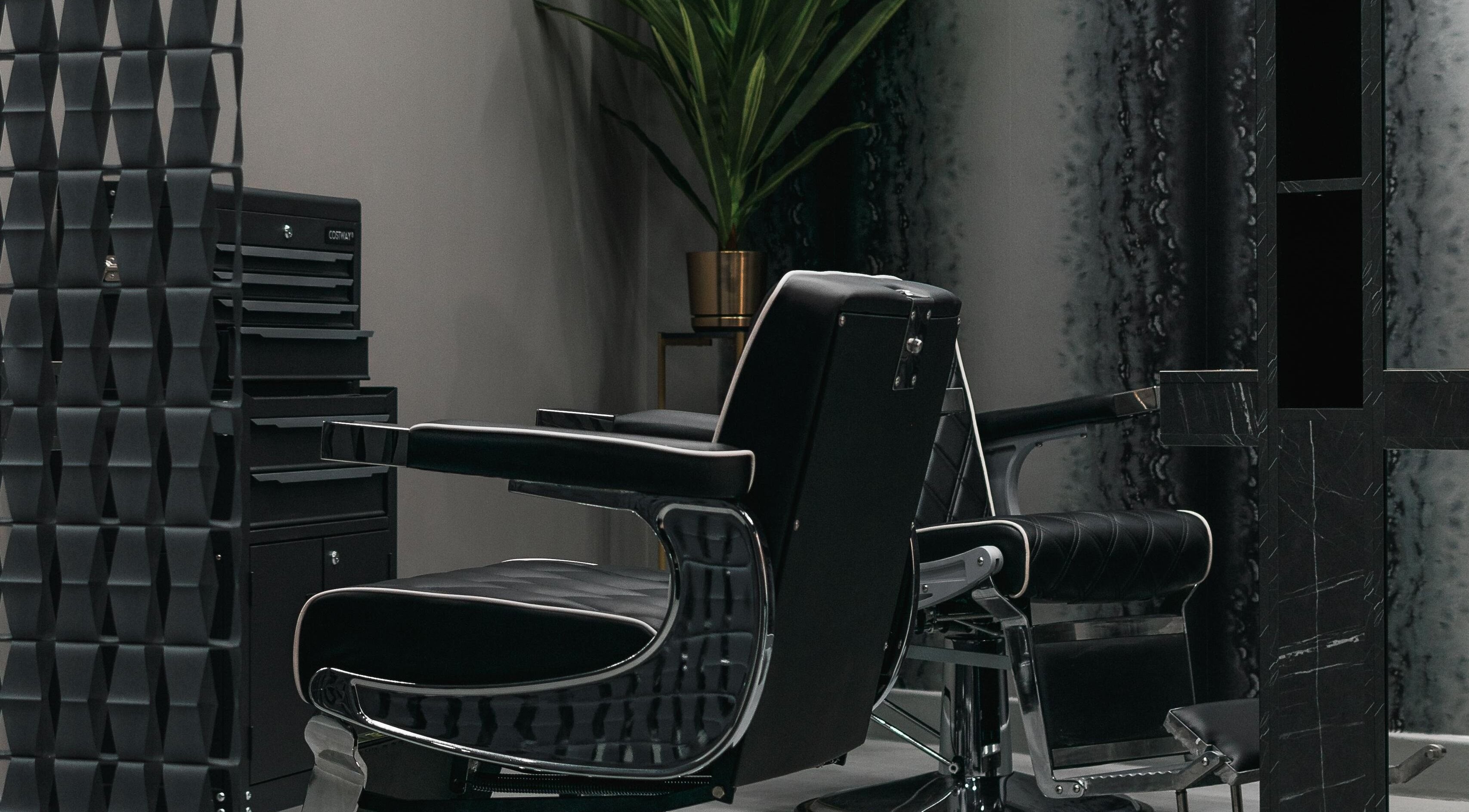 Luxurious barber chair at Collab Cuts, Lanark, Scotland, GB, set amid a sleek, modern interior.