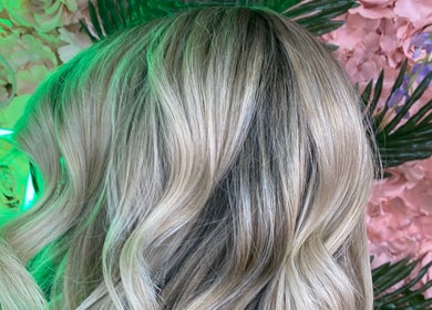 Blonde wavy hairstyle at Danielle Dunn Hairstylist & Extensionists, Motherwell, Scotland, GB amidst floral decor.