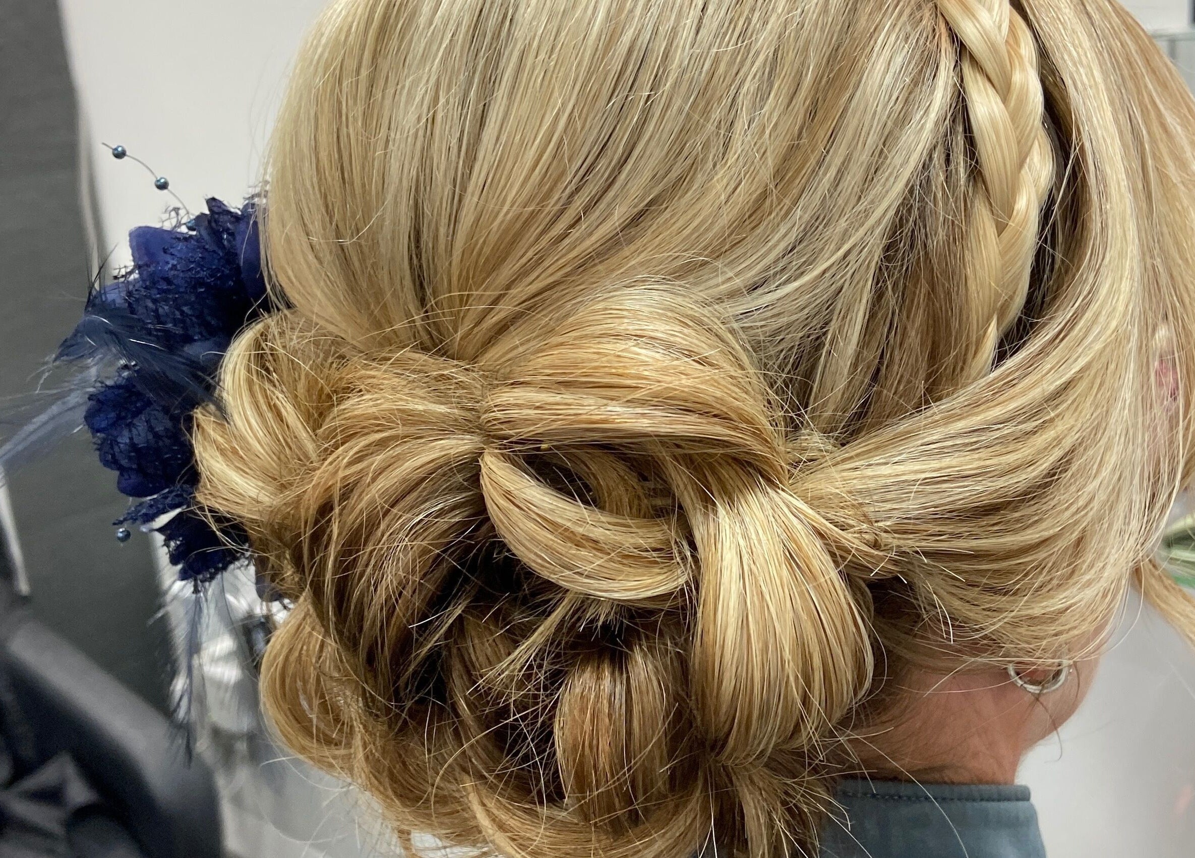 Elegant braided updo with floral detail at Danielle Dunn Hairstylist & Extensionists, Motherwell, Scotland, GB.