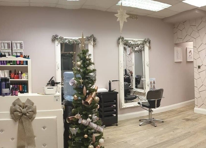 Elegant Cabello salon in Birstall, England, GB adorned with festive decor, mirrors, and styling chairs.