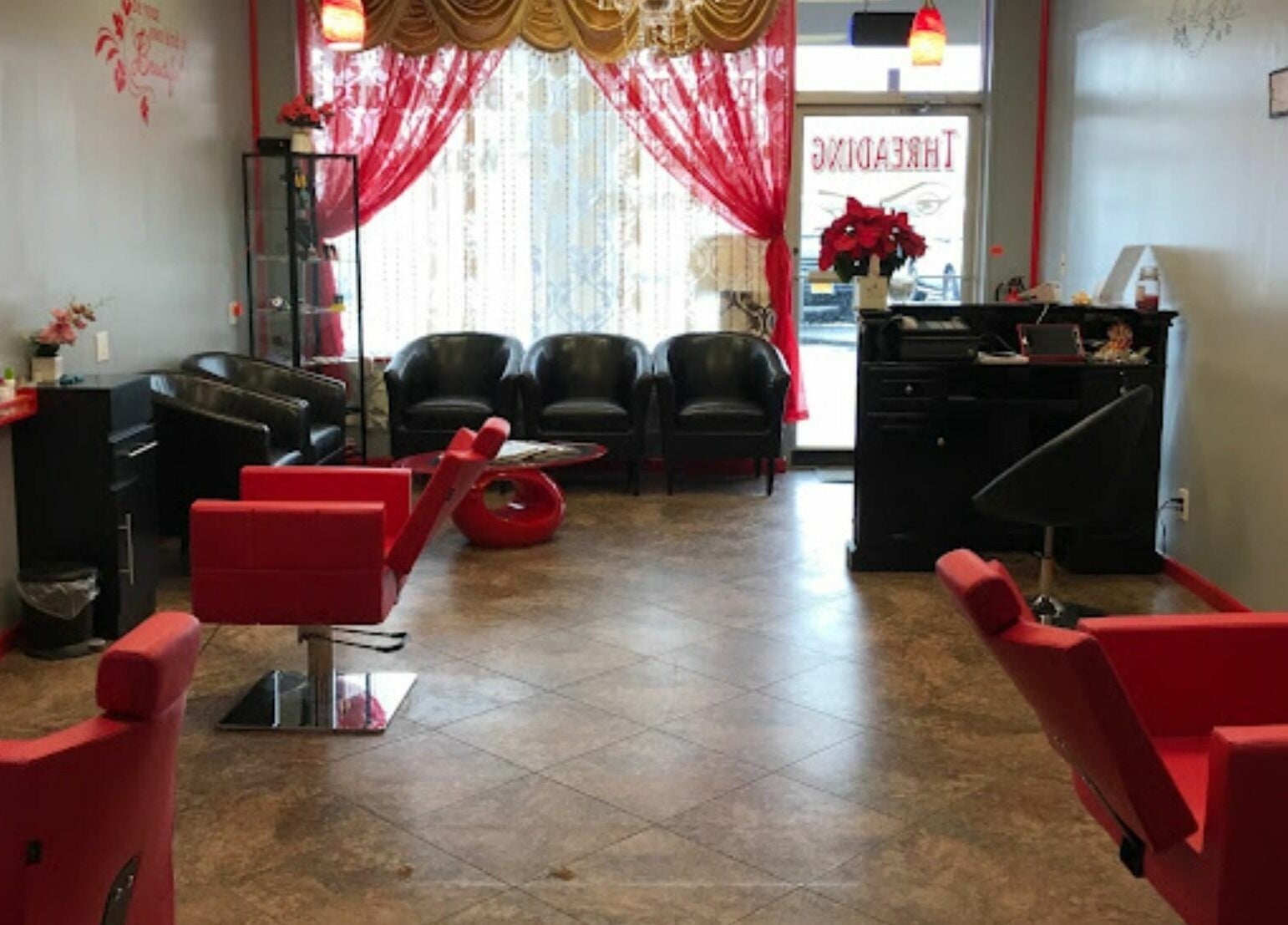 Cozy salon seating area at Makeover Planet in Poughkeepsie, New York, US with modern red accents.