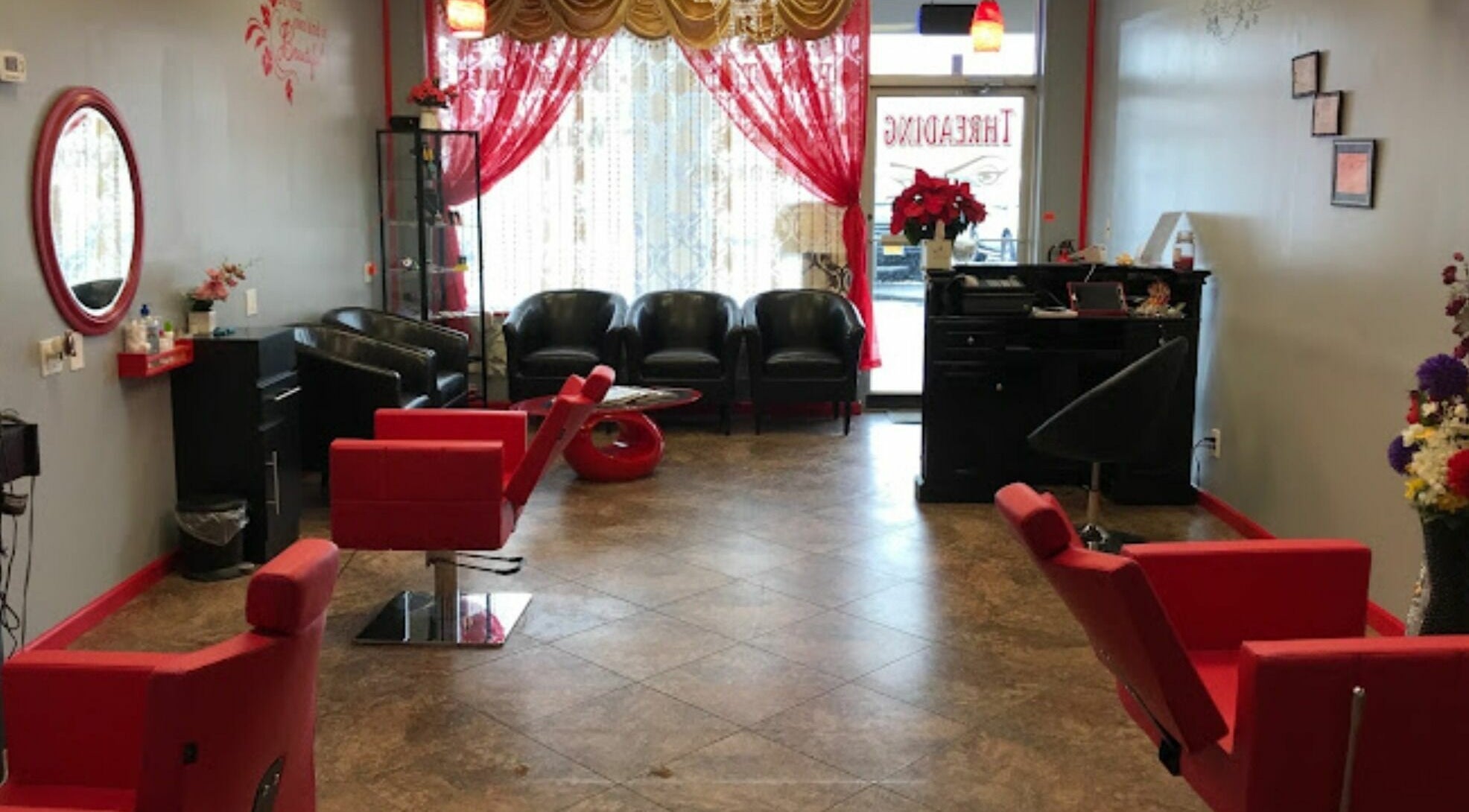 Cozy salon seating area at Makeover Planet in Poughkeepsie, New York, US with modern red accents.