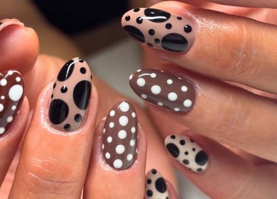 Close-up of polka-dot nail art design at Get The Gloss, Hamilton, Scotland, GB showcasing chic brown and black patterns.