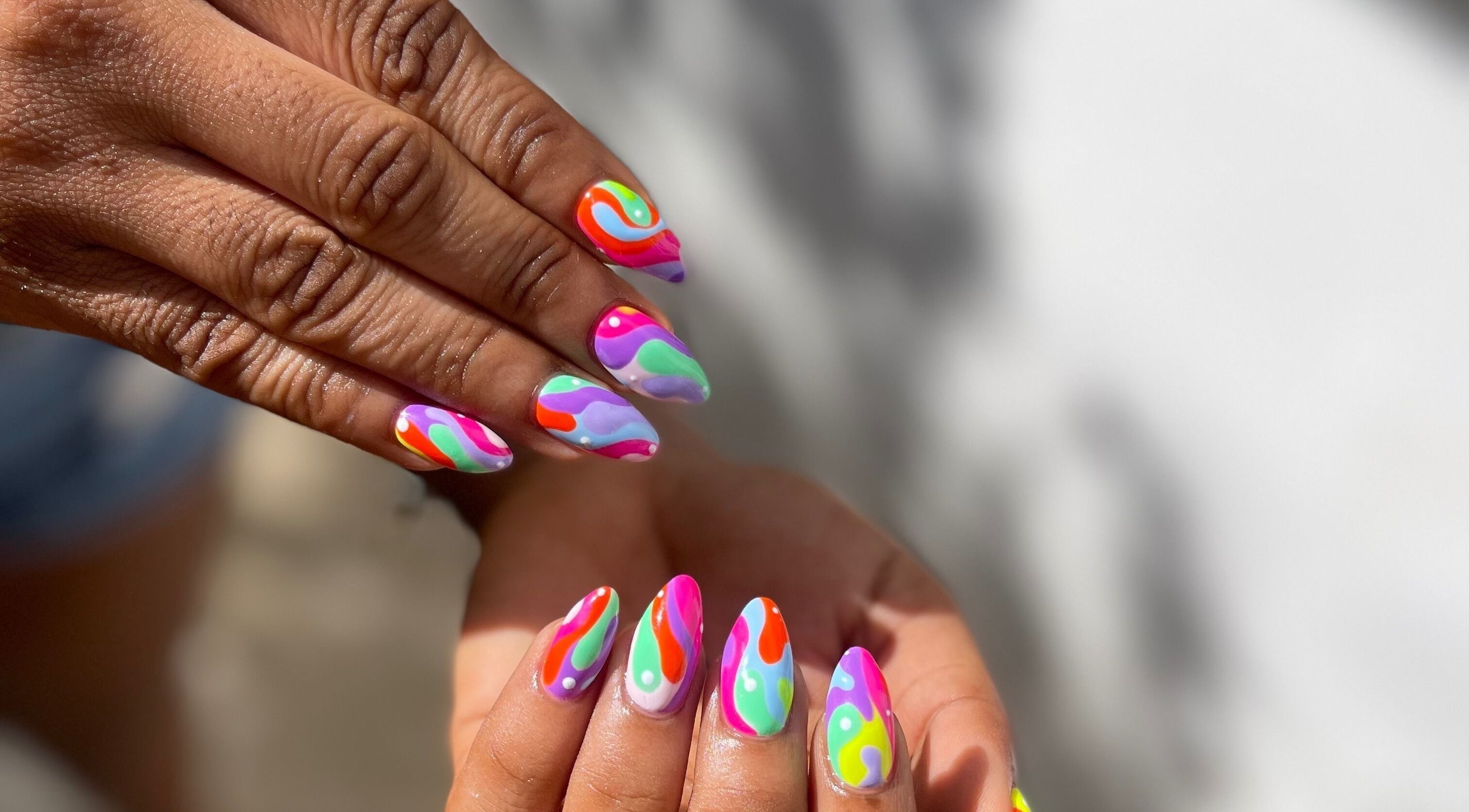Vibrant rainbow nail art at Slay By Daè, St. James, BB, showcasing detailed multicolor design.