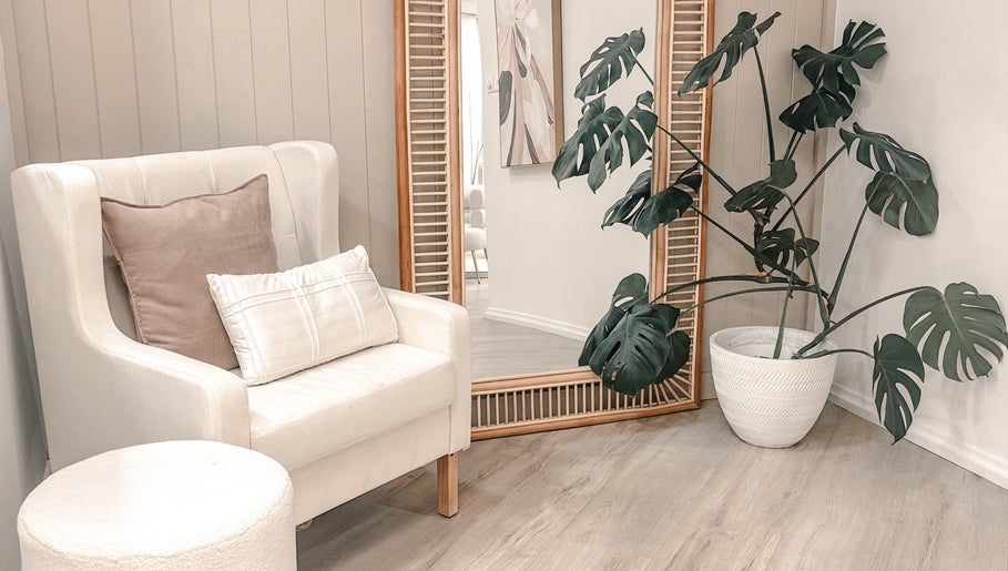Cozy lounge area in Zovia Beauty, Griffith, Australian Capital Territory, AU with chair, mirror, and plant.