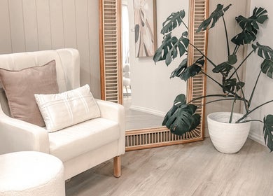 Cozy lounge area in Zovia Beauty, Griffith, Australian Capital Territory, AU with chair, mirror, and plant.
