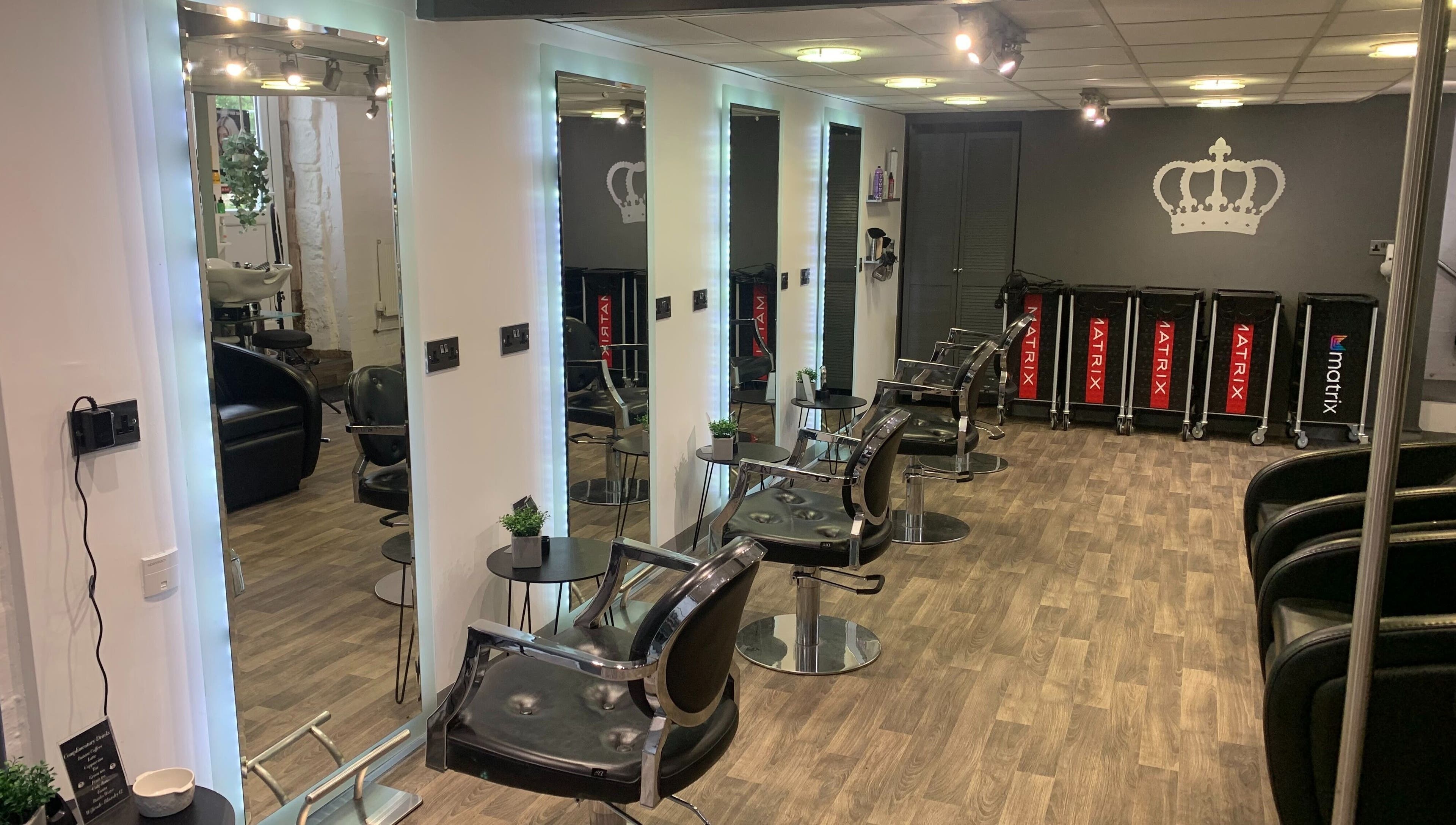 Modern salon interior at King's Hair Studio in Carlisle, England, GB, featuring sleek styling chairs and mirrors.