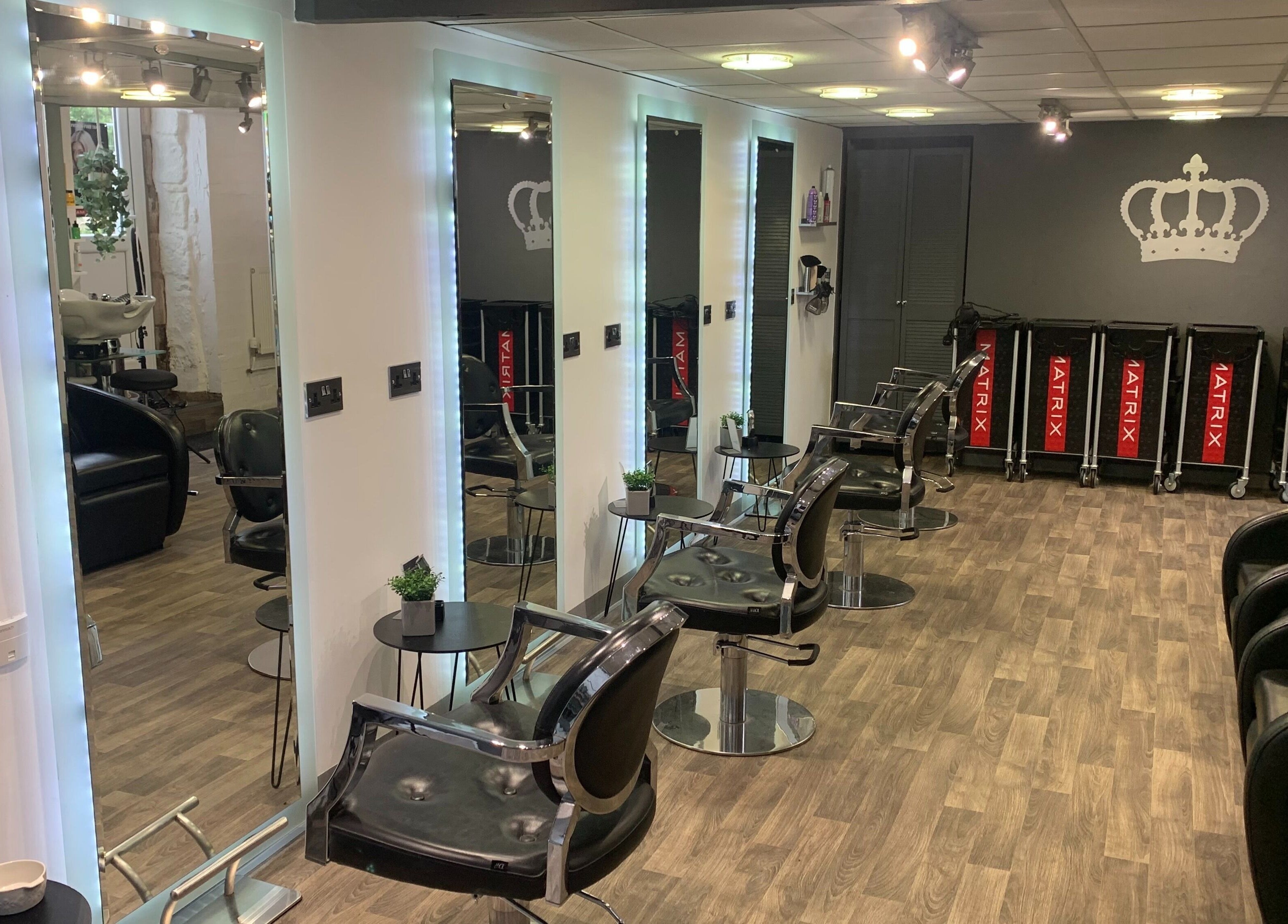 Modern salon interior at King's Hair Studio in Carlisle, England, GB, featuring sleek styling chairs and mirrors.