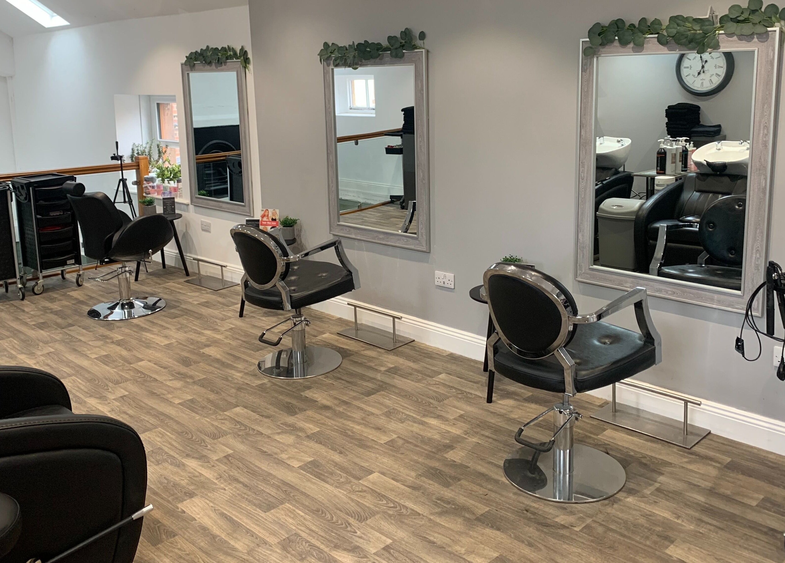Modern salon interior at King's Hair Studio, Carlisle, England, GB with stylish chairs and mirrors.