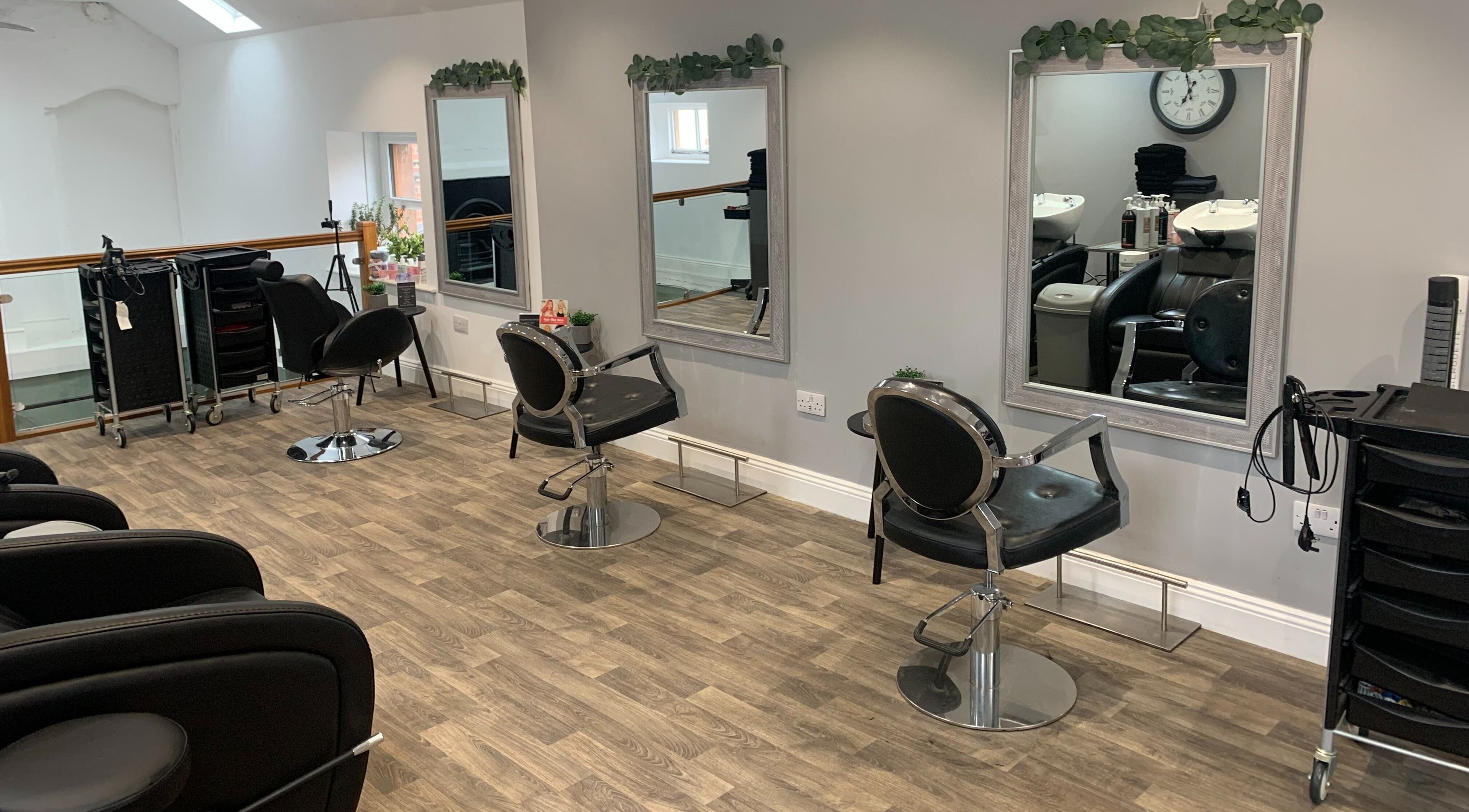 Modern salon interior at King's Hair Studio, Carlisle, England, GB with stylish chairs and mirrors.