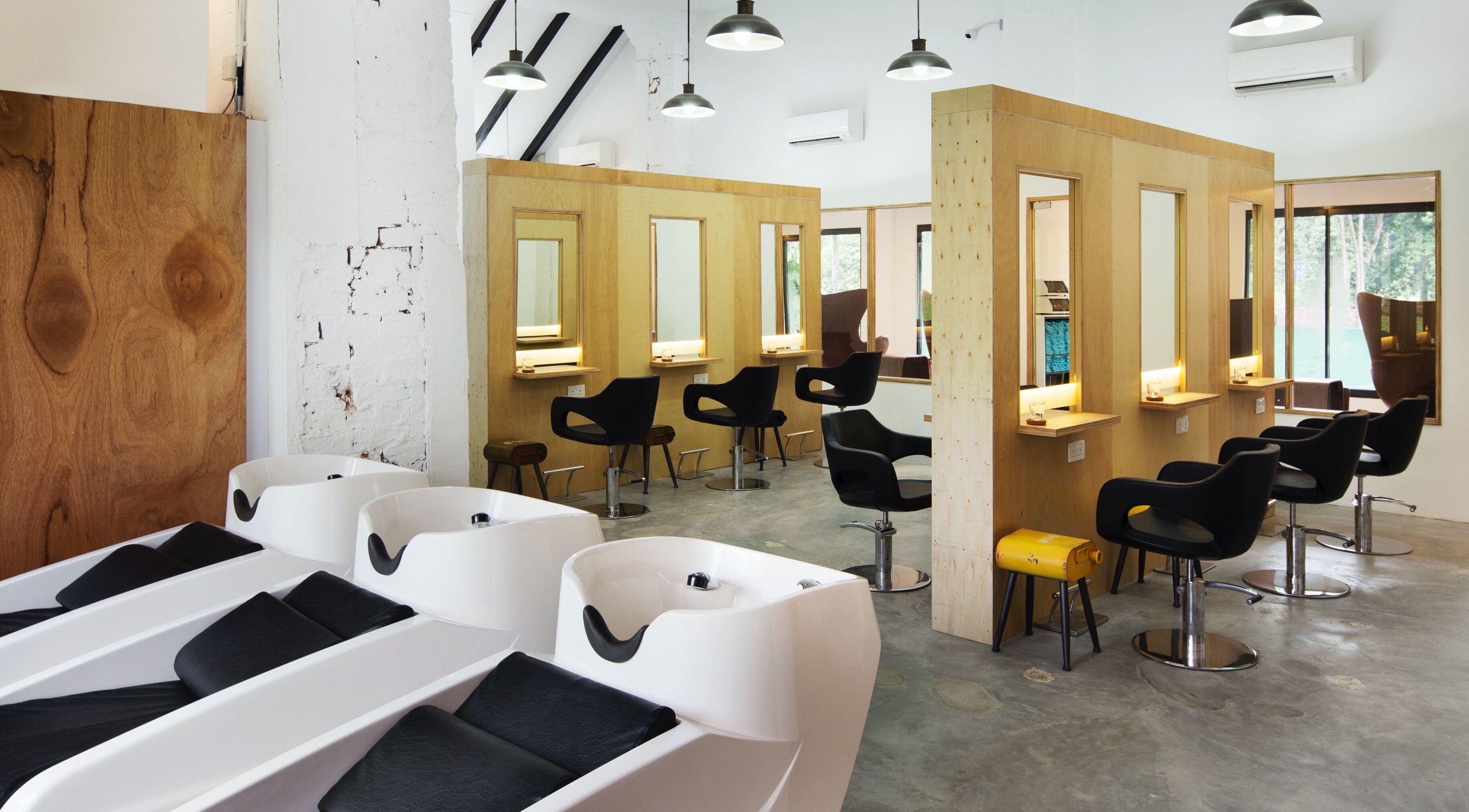 Interior of Trimmings Salon & Spa | Dempsey Hill in Singapore, featuring modern styling chairs and wash stations.