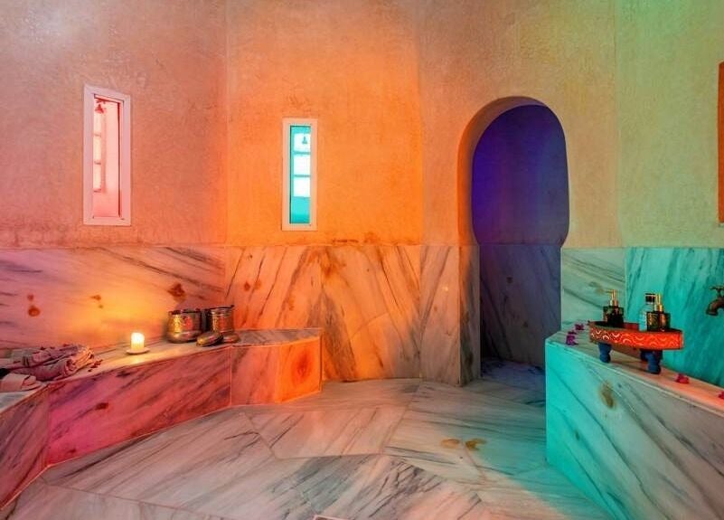 Relaxing Moroccan hammam at Spa Les Borjs de la Kasbah, Marrakesh, showcasing marble finishes and ambient lighting.