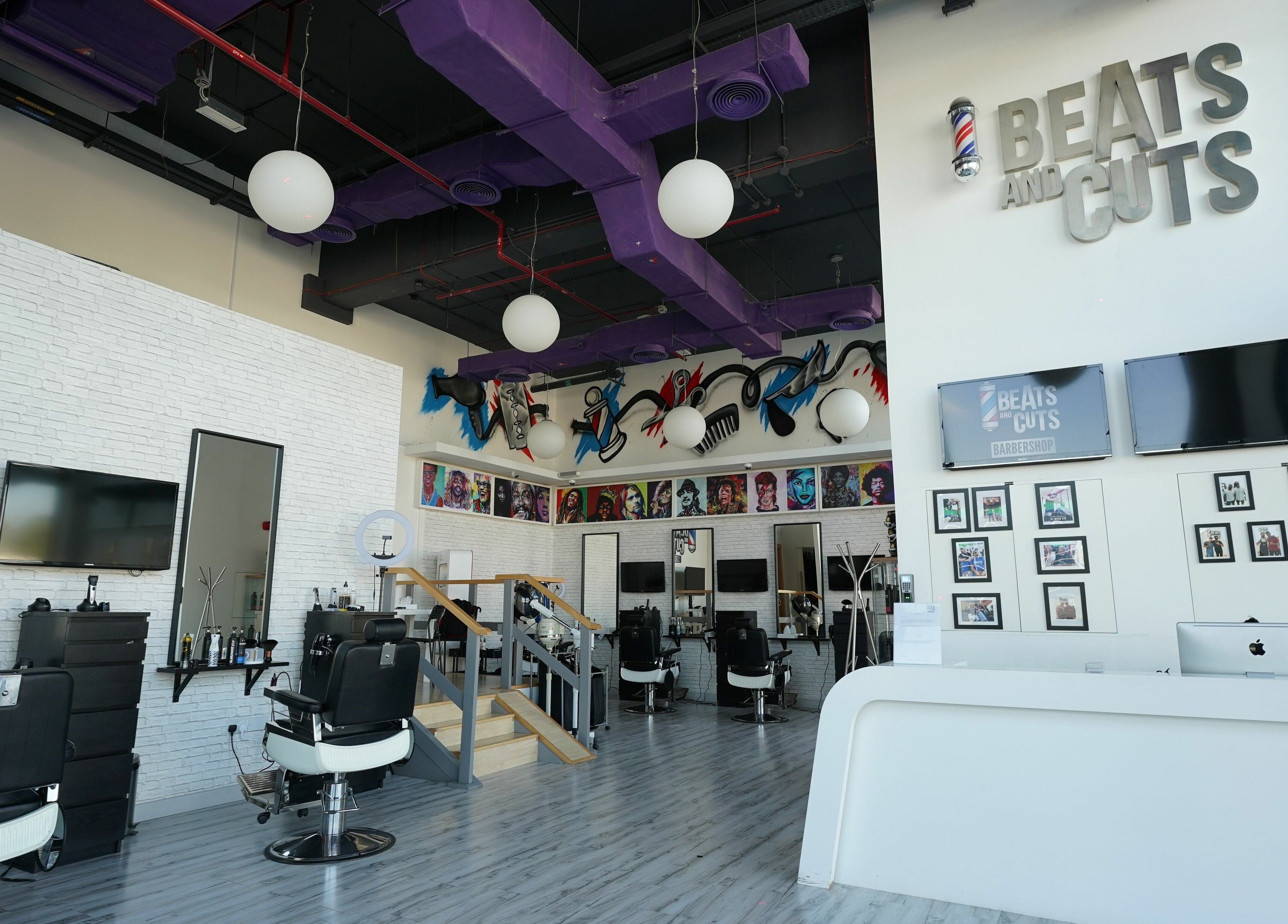 Stylish interior of Beats and Cuts in Dubai, AE. Modern design with sleek barber chairs and vibrant artwork.