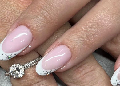 Elegant nail art with rings at Suzi Q Nails, Melbourne, Victoria, AU showcasing delicate pink and white design.
