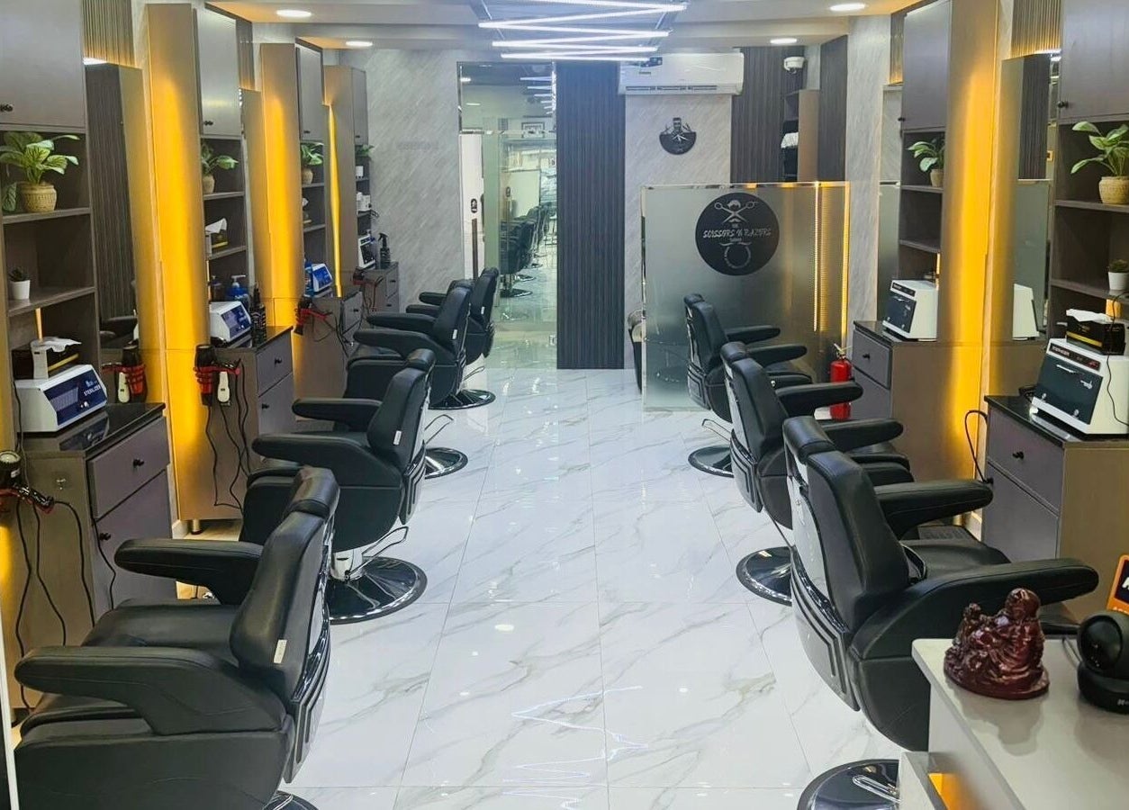 Modern interior of The Scissors N Razors Saloon in Abu Dhabi, Abu Dhabi, AE, featuring sleek styling chairs.