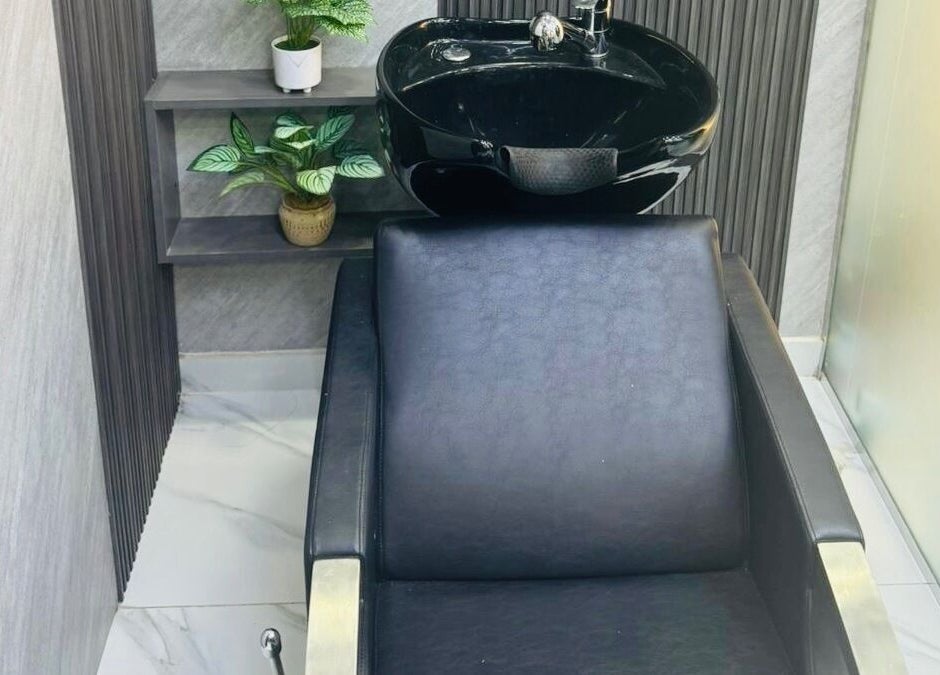 Modern wash station at The Scissors N Razors Saloon, Abu Dhabi, Abu Dhabi, AE, with black chair and basin.