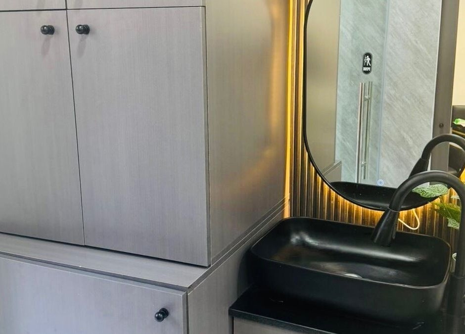 Elegant vanity at The Scissors N Razors Saloon, Abu Dhabi, AE features modern sink and mirror setup.